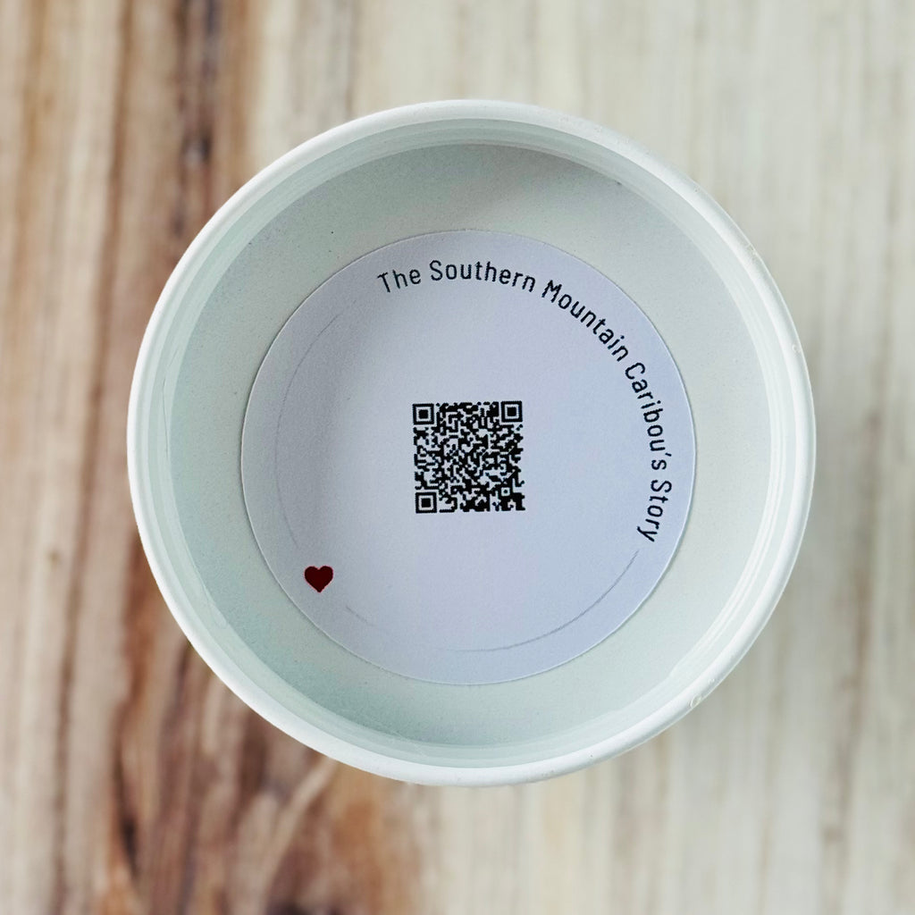 Product detail showing candle lid QR code linking to endangered caribou conservation content
