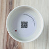 Product detail showing candle lid QR code linking to endangered crane conservation content
