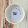 Product detail showing candle lid QR code linking to endangered pangolin conservation content
