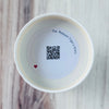 Product detail showing candle lid QR code linking to endangered rhino conservation content