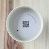 Product detail showing candle lid QR code linking to endangered crane conservation content
