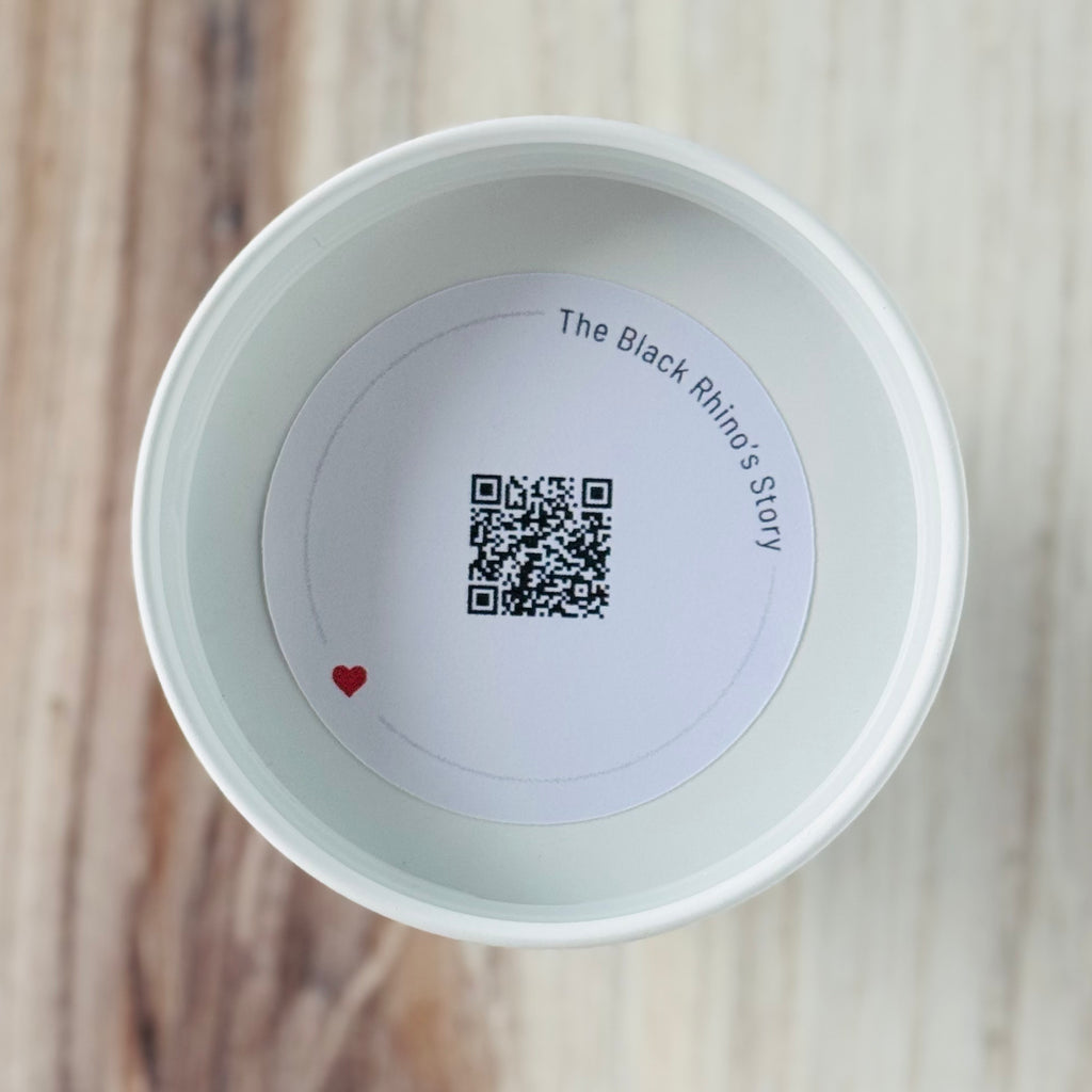 Product detail showing candle lid QR code linking to endangered rhino conservation content