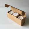 Three candles in a cardboard box on a white background