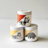 Three small container candles with lids and animal designs of a rhino, tiger, and pangolin on the labels