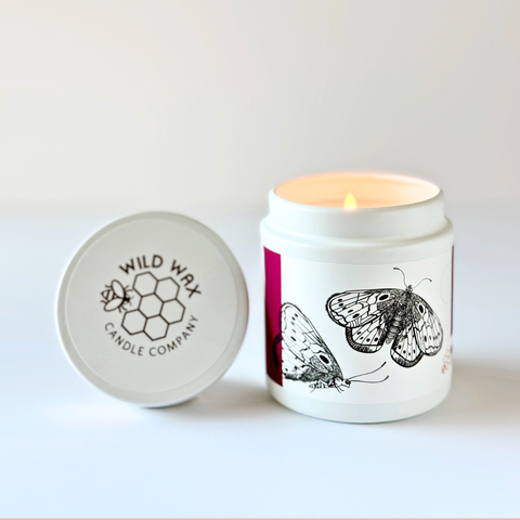 Candle with butterfly design and Wild Wax Candle Company lid on a white background