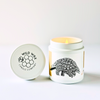 Hand-poured coconut wax candle featuring a pangolin design and branded wild wax candle company lid on white background 