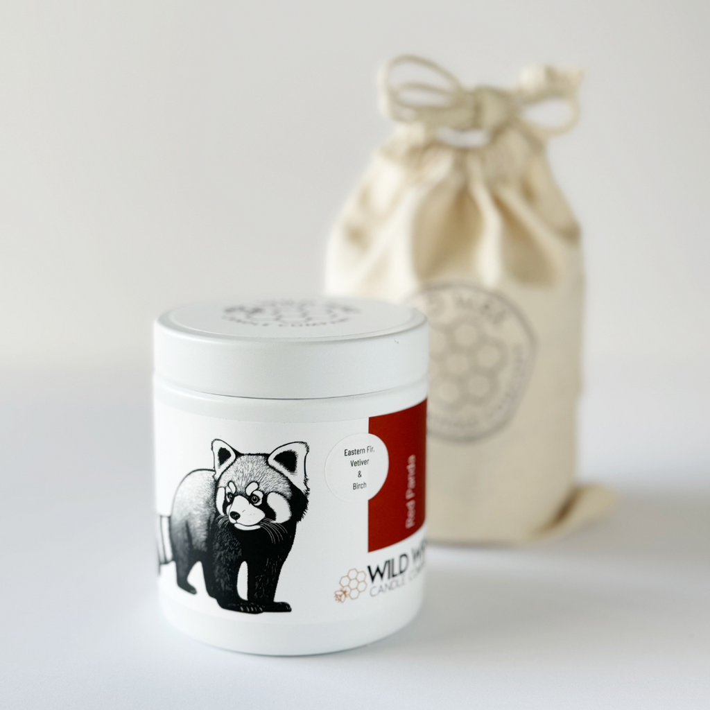 Minimal white candle container with lid featuring a red panda illustration and reusable linen bag packaging
