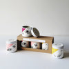 Set of three small candles with animal illustrations and a cardboard gift box on white background