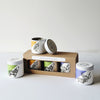 Set of three mini tin candles with animal illustrations and a cardboard packaging box on a white background.